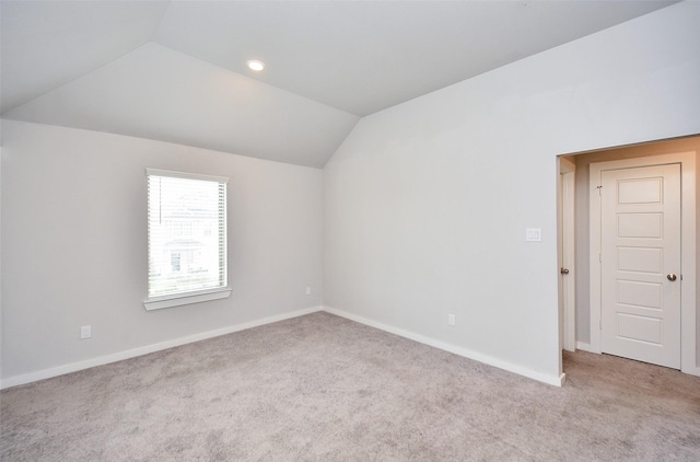 empty room featuring light carpet and lofted ceiling