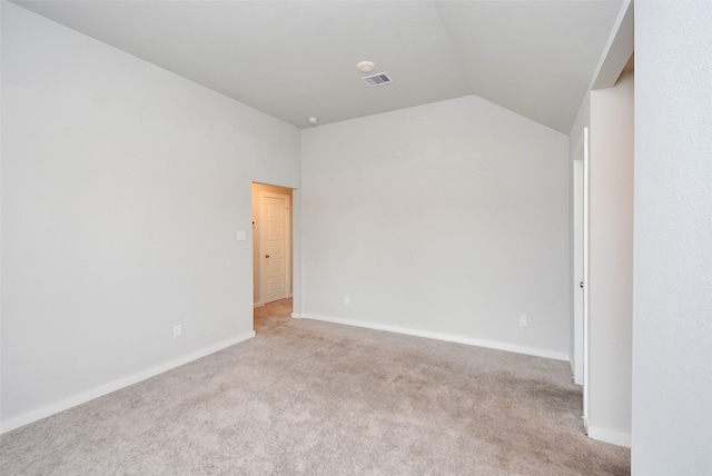 carpeted spare room with lofted ceiling