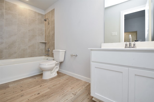 full bathroom featuring toilet, hardwood / wood-style floors, vanity, and tiled shower / bath