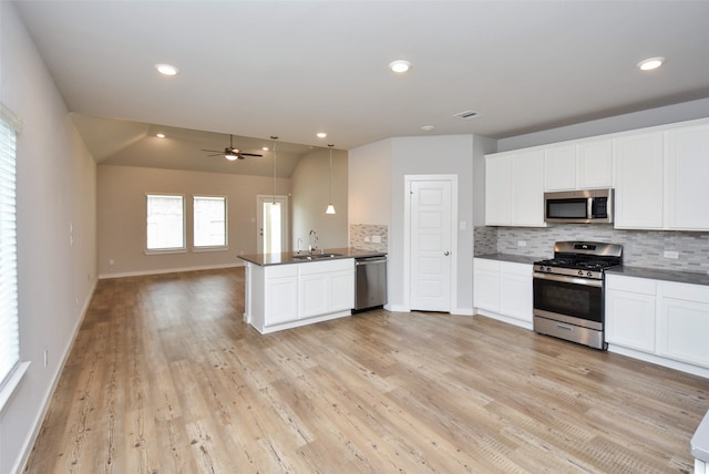 kitchen featuring white cabinets, stainless steel appliances, and vaulted ceiling