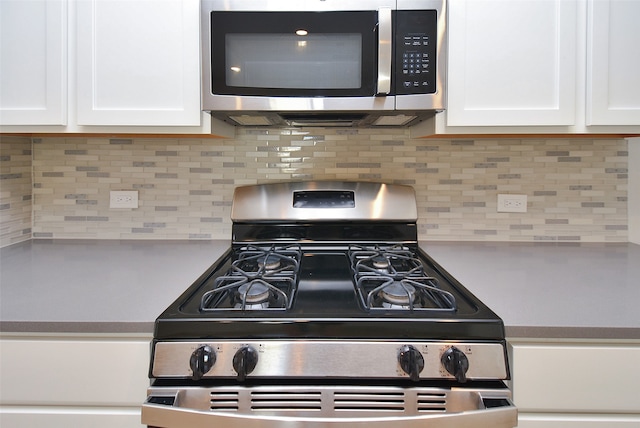 kitchen featuring backsplash, white cabinets, and stainless steel appliances