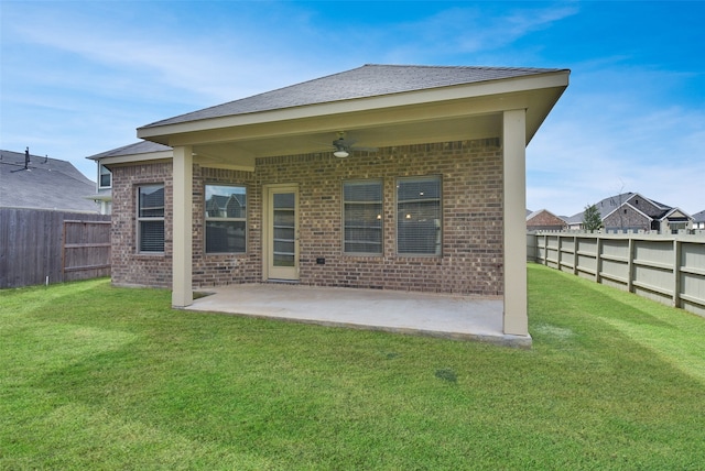 back of property featuring ceiling fan, a yard, and a patio