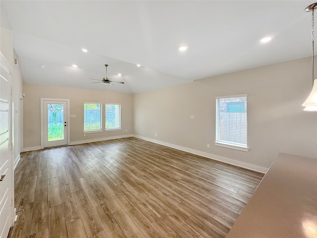 unfurnished living room with light hardwood / wood-style floors, ceiling fan, and vaulted ceiling