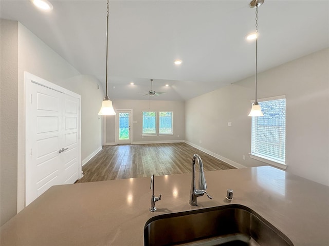 kitchen featuring sink, wood-type flooring, vaulted ceiling, pendant lighting, and ceiling fan