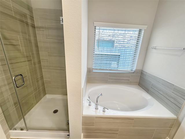 bathroom featuring shower with separate bathtub