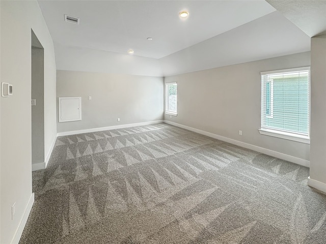 spare room with plenty of natural light, carpet, and lofted ceiling