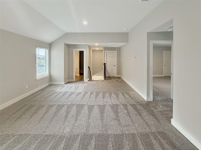 unfurnished living room with vaulted ceiling and carpet floors