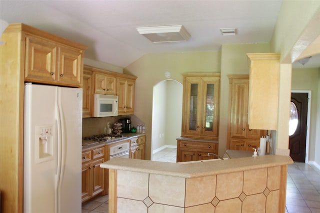 kitchen with light brown cabinets, white appliances, light tile patterned floors, and lofted ceiling