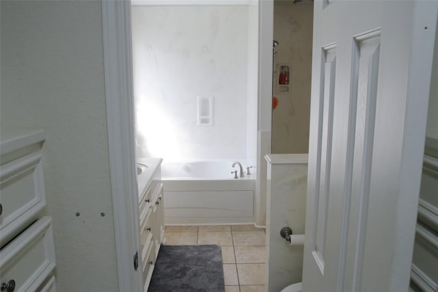 bathroom with tile patterned flooring, vanity, and a bath