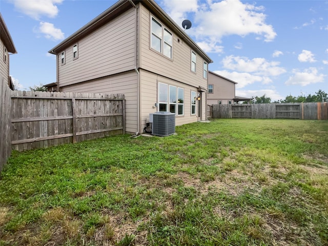 back of house featuring cooling unit and a lawn