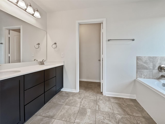 bathroom with tile patterned floors, a tub to relax in, and vanity