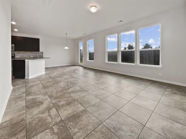 unfurnished living room with sink and a wealth of natural light