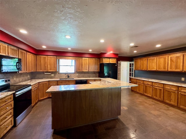 kitchen with sink, backsplash, black appliances, and a center island