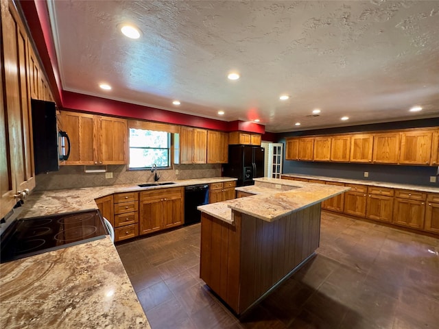 kitchen with sink, a center island, light stone counters, tasteful backsplash, and black appliances