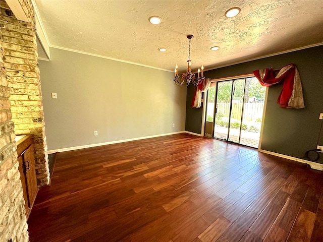 unfurnished room with crown molding, a large fireplace, dark hardwood / wood-style flooring, and a chandelier