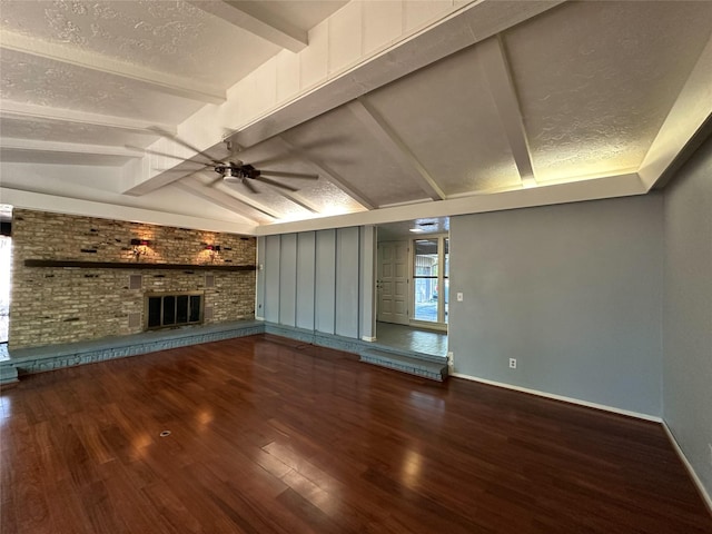 unfurnished living room featuring a brick fireplace, wood-type flooring, vaulted ceiling with beams, and a textured ceiling