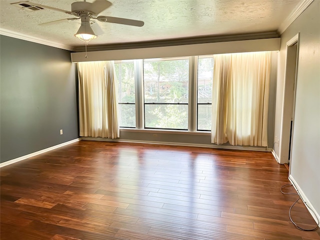 empty room with ceiling fan, crown molding, dark wood-type flooring, and a textured ceiling