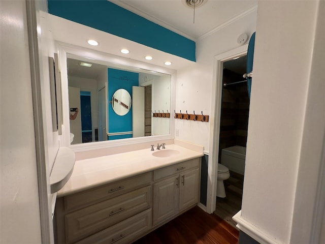 bathroom with vanity, hardwood / wood-style flooring, ornamental molding, and toilet