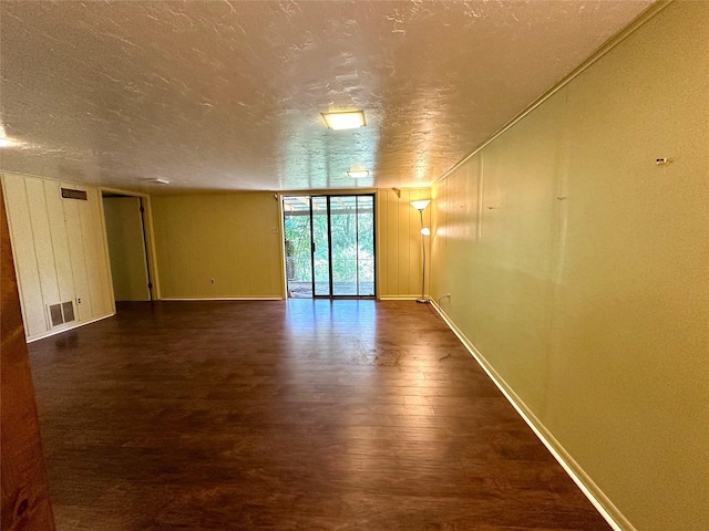 spare room with dark wood-type flooring and a textured ceiling