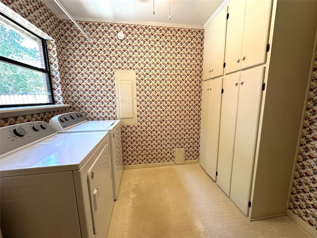 laundry area featuring ornamental molding, washer and clothes dryer, electric panel, and cabinets