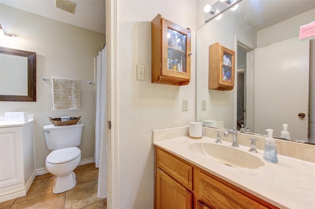 bathroom featuring toilet, tile patterned floors, and vanity