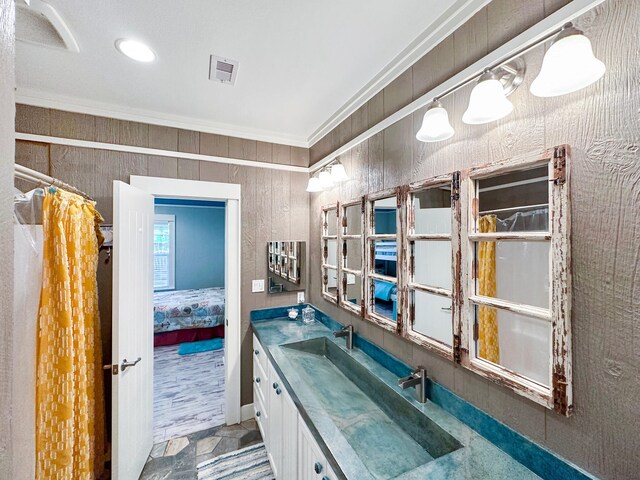 bathroom with wooden walls, vanity, and crown molding