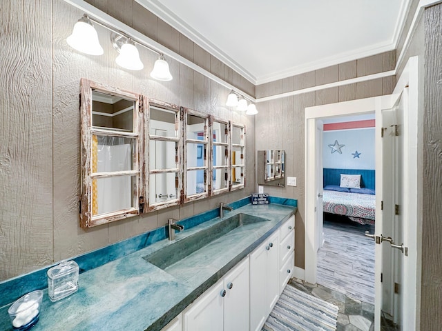 bathroom with wooden walls, tile flooring, crown molding, and vanity