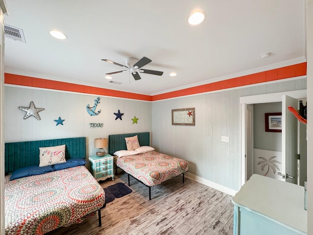 bedroom with hardwood / wood-style floors, ornamental molding, and ceiling fan