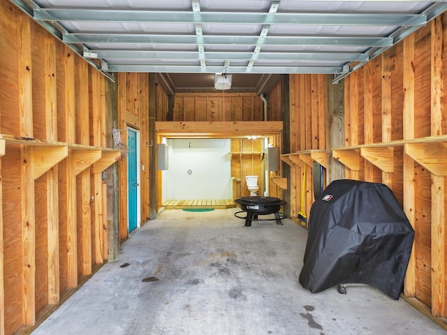 garage with a garage door opener and wooden walls