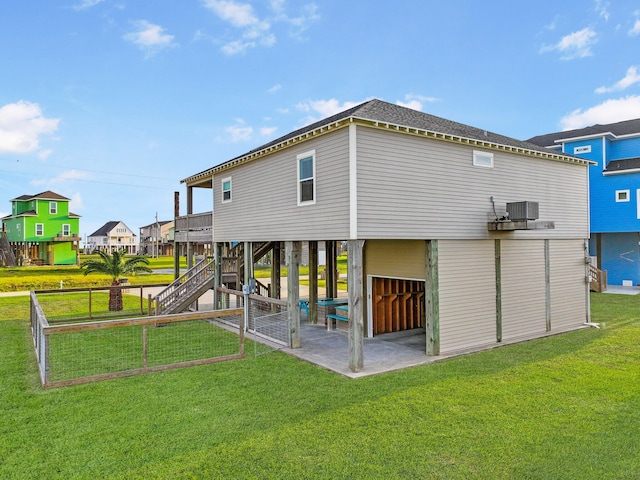 rear view of house featuring a yard, central AC unit, and a patio