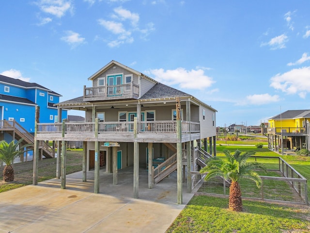 view of front facade featuring a carport, covered porch, a balcony, and a front lawn