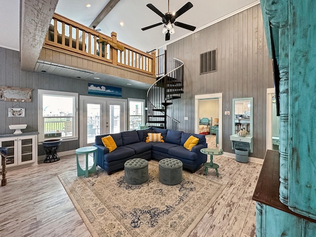 living room featuring ceiling fan, french doors, a towering ceiling, and hardwood / wood-style flooring