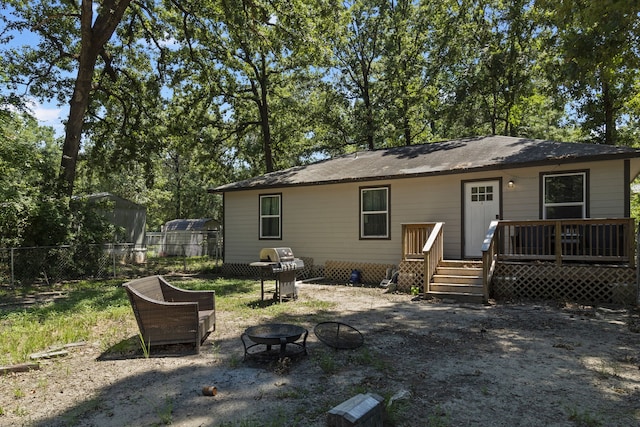 rear view of house featuring a fire pit and a deck