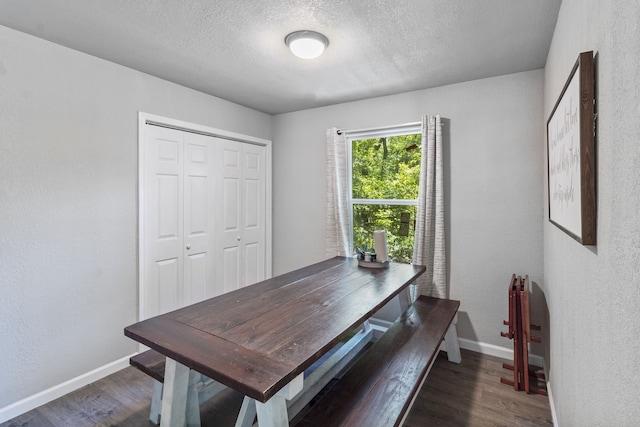 dining space featuring dark hardwood / wood-style floors and a textured ceiling