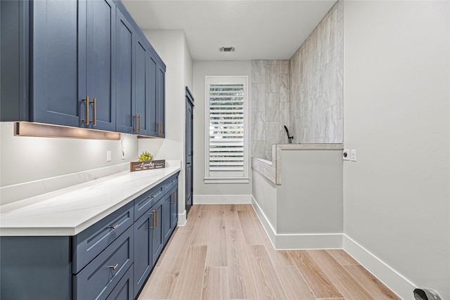 interior space with blue cabinetry and light hardwood / wood-style flooring