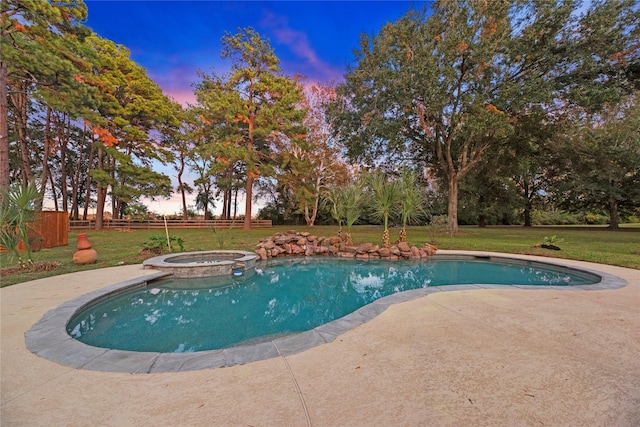 pool at dusk featuring a patio, a lawn, and an in ground hot tub