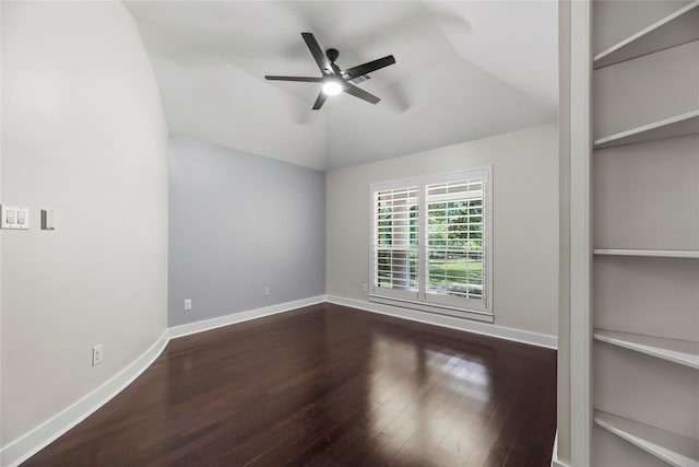 unfurnished room with dark hardwood / wood-style flooring, ceiling fan, vaulted ceiling, and built in features