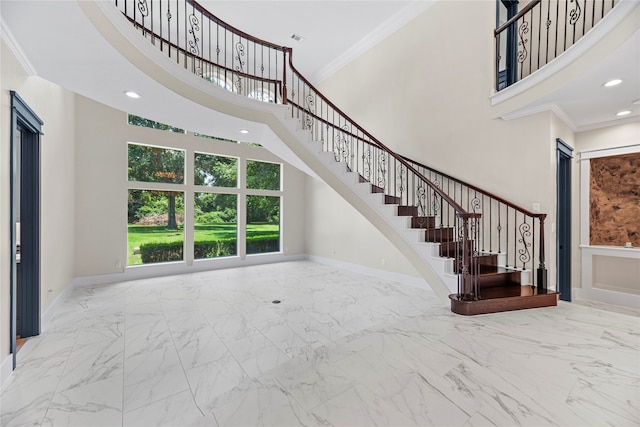 interior space with a towering ceiling and ornamental molding