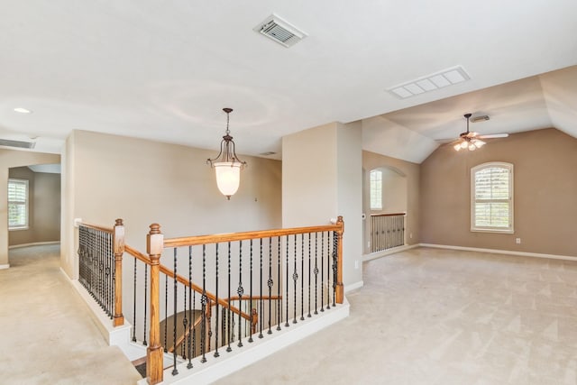 corridor featuring light colored carpet and lofted ceiling