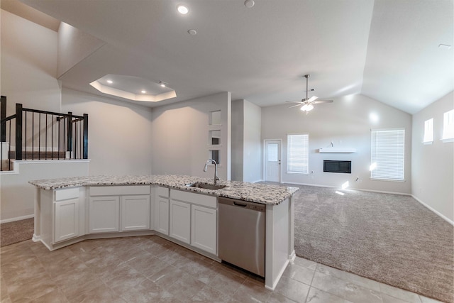 kitchen featuring light stone counters, sink, stainless steel dishwasher, white cabinetry, and light carpet