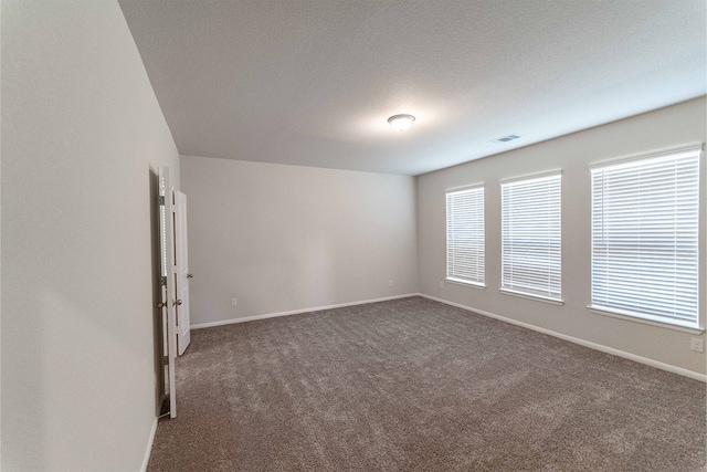 carpeted spare room featuring a textured ceiling