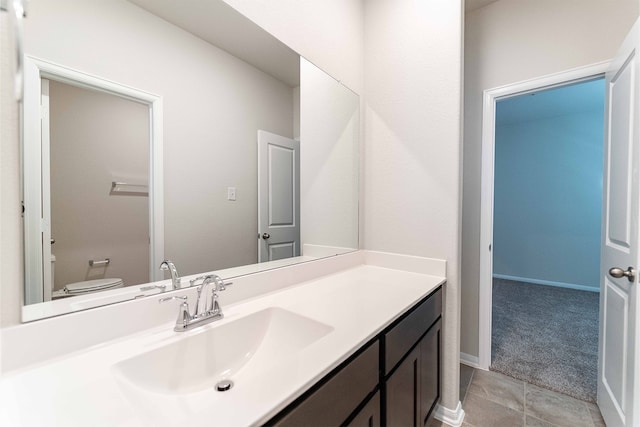 bathroom with vanity, tile patterned flooring, and toilet