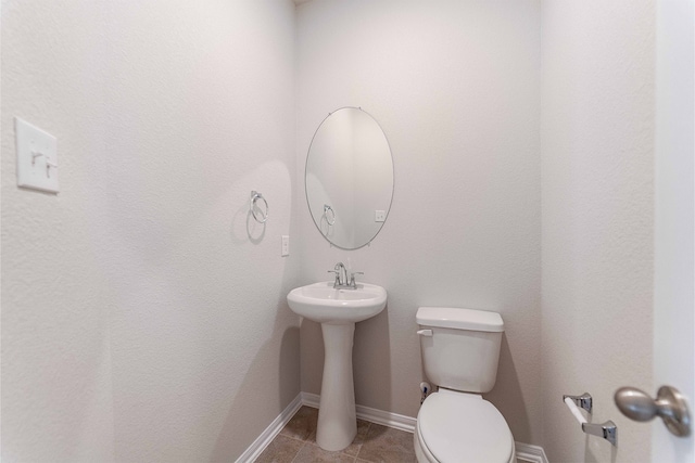 bathroom with sink, toilet, and tile patterned floors