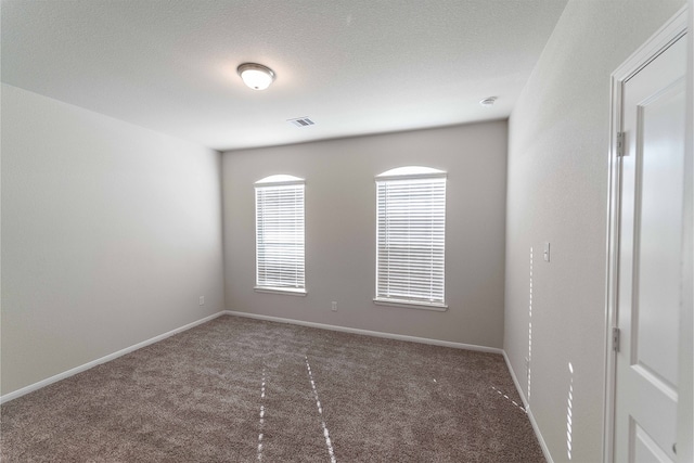 carpeted empty room with a textured ceiling