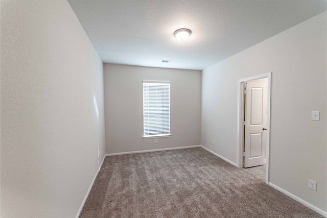 carpeted spare room with a textured ceiling