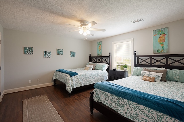 bedroom with ceiling fan, dark wood-type flooring, and a textured ceiling