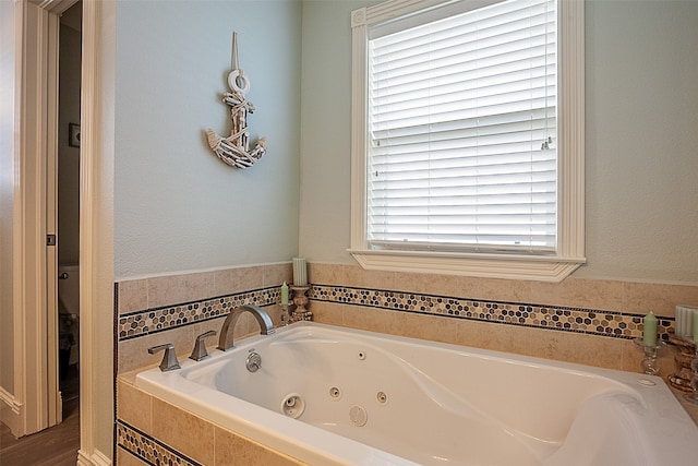 bathroom with a relaxing tiled tub