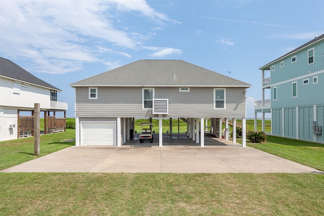 rear view of property with a garage and a lawn