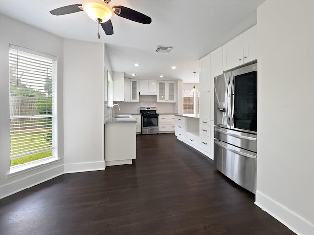 kitchen featuring sink, white cabinetry, tasteful backsplash, hanging light fixtures, and appliances with stainless steel finishes