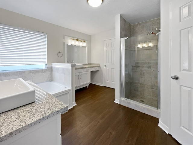 bathroom featuring hardwood / wood-style flooring, independent shower and bath, and vanity